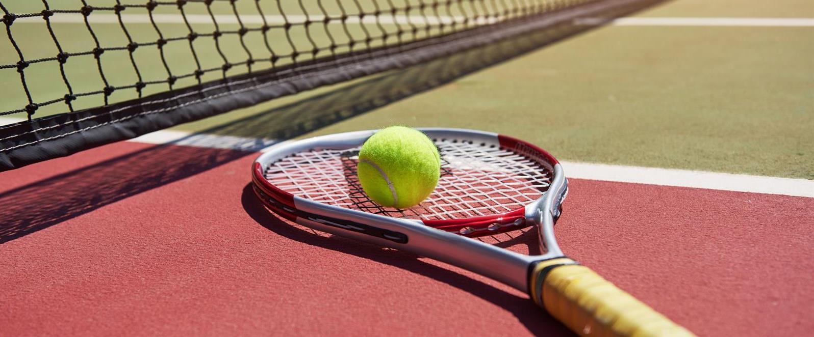 tennis-racket-and-new-tennis-ball-on-freshly-painted-tennis-court